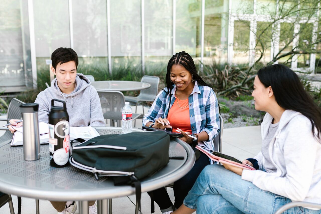 Diverse group of university students studying together outdoors