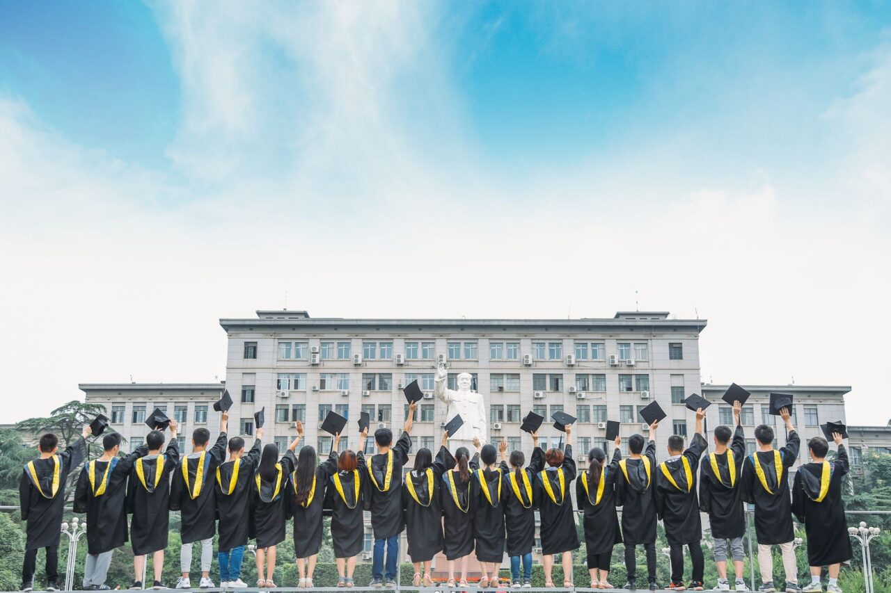 Graduates celebrating outdoors with caps in the air