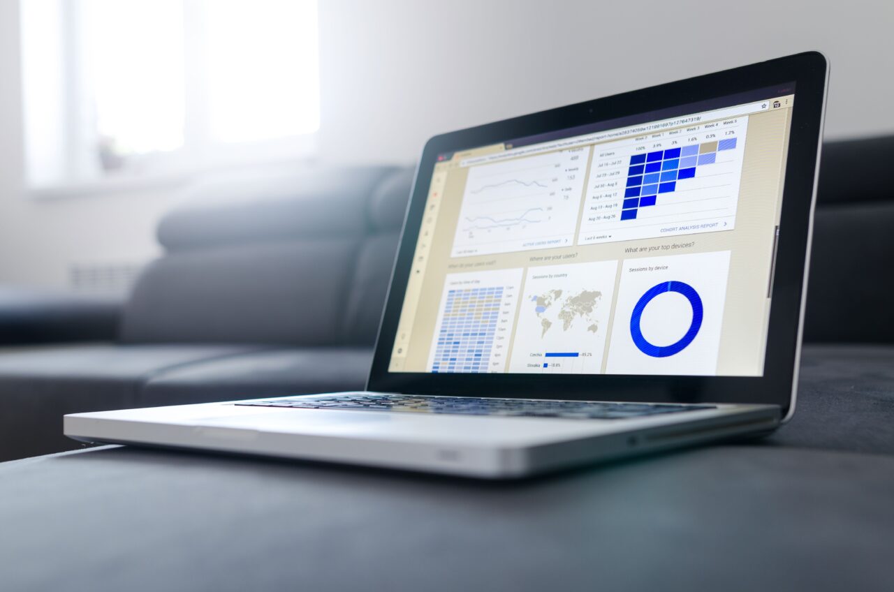 Laptop screen displaying a data analytics dashboard with charts and graphs